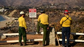 Des pompiers observent les montagnes brûlées de Santa Monica depuis le quartier de Pacific Palisades à Los Angeles, en Californie, le 13 janvier 2025.