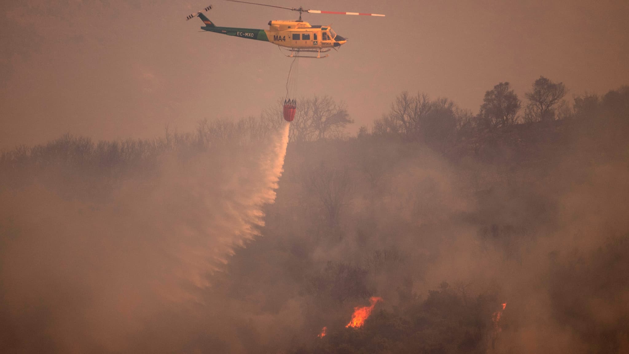 Un hélicoptère effectue un largage au-dessus un incendie dans les montagnes des Mijas, en Espagne, le 15 juillet 2022. Un hélicoptère effectue un largage au-dessus un incendie dans les montagnes des Mijas, en Espagne, le 15 juillet 2022.