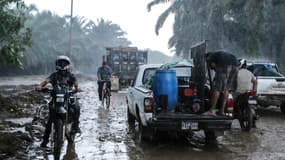 Des habitants quittent leur maison sous une pluie battante dans  la municipalité d'El Progreso, Honduras, avant l'arrivée de la tempête tropicale Julia, le 8 octobre 2022.