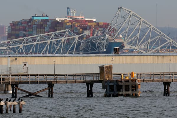 Des résidents locaux observent un cargo qui s'est écrasé sur le pont Francis Scott Key le 26 mars 2024 à Baltimore, dans le Maryland.