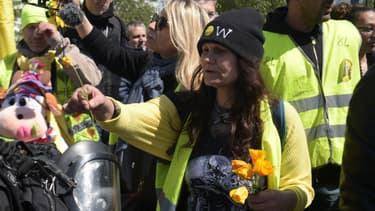 Une manifestante tend des fleurs à des CRS à Paris.
