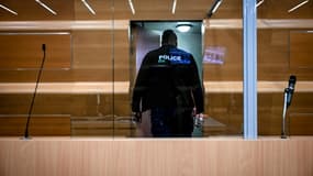 Un policier inspecte le box des accusés dans la salle d'audience du tribunal de Grenoble le 13 mai 2024. Photo d'illustration