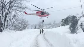 Les pompiers en train d'hélitreuiller une personne retrouvée près de l'hôtel enseveli par la neige après une avalanche, dans le centre de l'Italie.