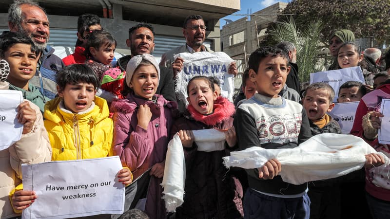 Des hommes et des enfants palestiniens appellent à la poursuite du soutien international à l'Office de secours et de travaux des Nations Unies pour les réfugiés de Palestine dans le Proche-Orient (UNRWA) à Rafah, le 30 janvier 2024.
