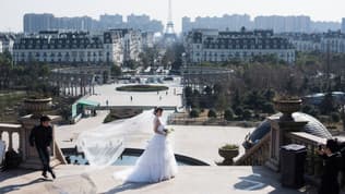 Un couple de mariés chinois pose devant la réplique de la tour Eiffel de Tianducheng le 26 janvier 2016