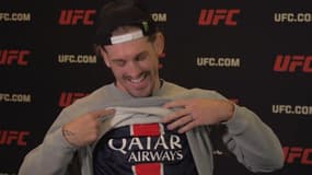 Le combattant américain Brendan Allen montre son maillot du PSG avant son combat face à Imavov