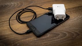 Un smartphone avec un chargeur.