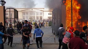 Des supporters du club de football Al-Ahly fuyant les flammes qui dévastent le club de la police.