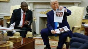 Le président américain Donald Trump brandit un article d'American Thinker en accusant le président sud-africain Cyril Ramaphosa de violences d'État contre des agriculteurs blancs, le 21 mai 2025 à Washington.