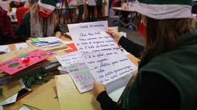 Des employés de La Poste ouvrent les lettres du Père Noël écrites par des enfants au bureau de poste de Libourne, dans le sud-ouest de la France, le 10 décembre 2020