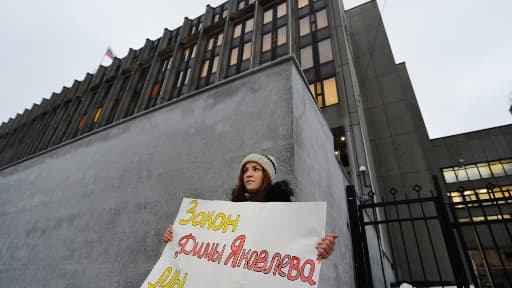 Une femme brandit : "Nous soutenons la loi Dima Iakoulev" devant la chambre haute du Parlement, Moscou, le 26 décembre au matin.