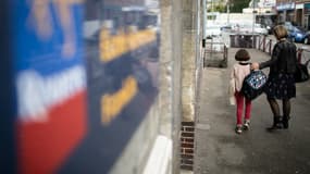 Une femme et un enfant devant une école élémentaire de Rouen (photo d'illustration).