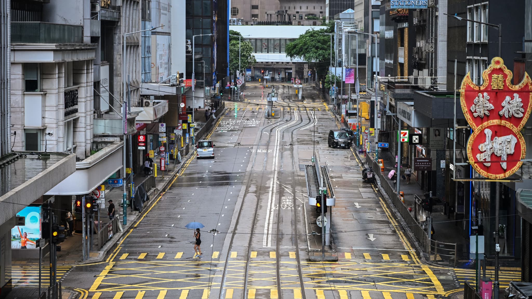 A woman crosses an empty street in the Central District, while Wipha's typhoon addresses Hong Kong on July 20, 2025.