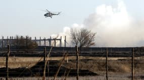 Un hélicoptère militaire survole le site de l'explosion de munition à Svatové, dans l'est de l'Ukraine, le 30 octobre 2015