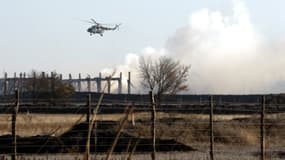 Un hélicoptère militaire survole le site de l'explosion de munition à Svatové, dans l'est de l'Ukraine, le 30 octobre 2015