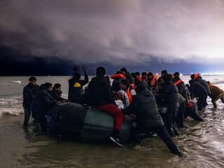 Des migrants montent à bord d'un canot gonflable pour tenter de traverser la Manche, sur la plage de Blériot à Sangatte (Pas-de-Calais) le 30 octobre 2024