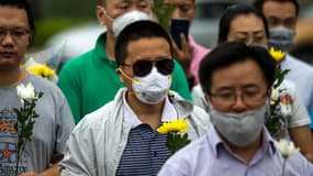 Des habitants de Tianjin rendent hommage aux victimes de l'explosion, protégés par des masques