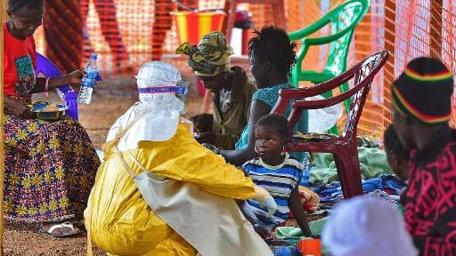 Un employé de Médecins sans frontières (MSF) nourrit un enfant victime du virus Ebola, le 15 août 2014 à Kailahun, au Sierra Leone Un employé de Médecins sans frontières (MSF) nourrit un enfant victime du virus Ebola, le 15 août 2014 à Kailahun, au Sierra Leone
