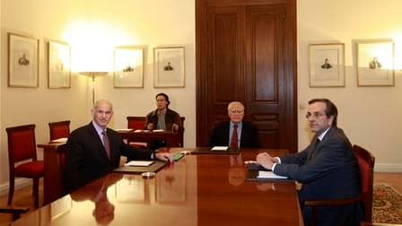 Autour du président Karolos Papoulias (au centre), le Premier ministre grec George Papandréou et le chef de l'opposition conservatrice Antonis Samaras ont trouvé un accord dimanche sur la formation d'un gouvernement de coalition pour sortir le pays de l'i