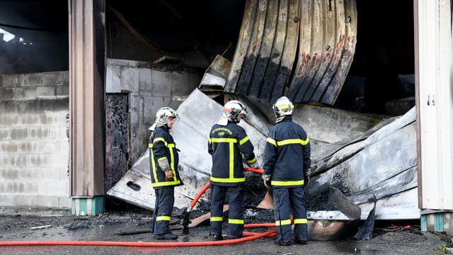 Des pompiers après l'incendie dans la caserne de gendarmerie à Grenoble le 21 septembre 2017
