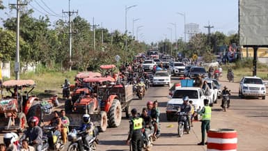 Une photo prise et diffusée par l'Agence Kampuchea Press (AKP) le 8 décembre 2025 montre des habitants évacuant leur domicile à la suite d'affrontements le long de la frontière entre le Cambodge et la Thaïlande, dans la province d'Oddar Meanchey.
