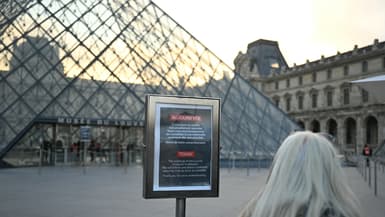 Une femme consulte une affiche informant le public du report de l'ouverture du musée du Louvre, tandis que les employés se réunissent en assemblée générale pour voter sur l'appel des syndicats à une grève illimitée contre la dégradation constante des conditions de travail et la baisse de l'expérience des visiteurs dans ce musée de renommée mondiale, à Paris, le 15 décembre 2025.