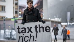 L'héritière et militante autrichienne Marlene Engelhorn avec une pancarte sur laquelle "Taxons les riches" lors du Forum économique mondial (WEF) à Davos (Suisse), le 15 janvier 2024 (photo d'illustration).