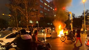 Des manifestants se rassemblant autour d'une barricade en feu lors d'une manifestation pour Mahsa Amini à Téhéran, le 19 septembre 2022.