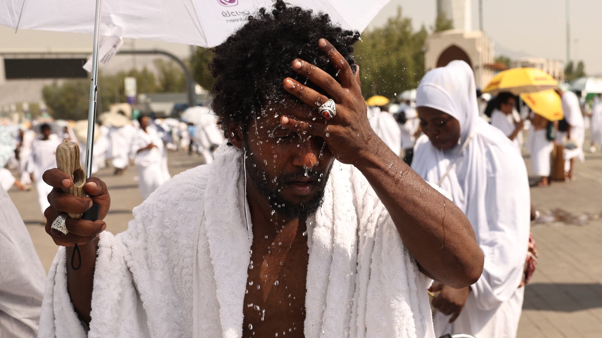 Un pèlerin musulman s'asperge la tête d'eau pour se rafraîchir au pied du mont Arafat en Arabie saoudite, lors du pèlerinage du Hajj, le 15 juin 2024. Un pèlerin musulman s'asperge la tête d'eau pour se rafraîchir au pied du mont Arafat en Arabie saoudite, lors du pèlerinage du Hajj, le 15 juin 2024.