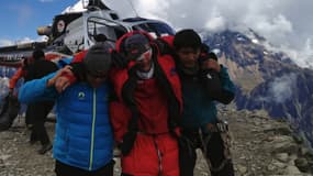 Des sauveteurs aident un alpiniste après une avalanche au Népal qui a fait au moins 9 morts.