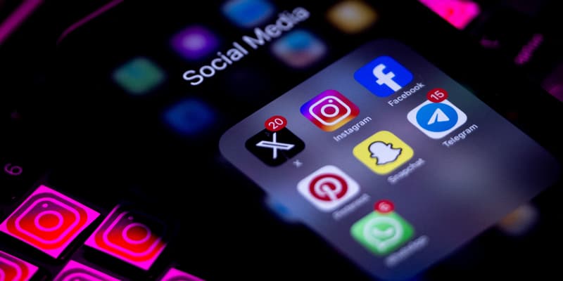 Les écrans de téléphones portables affichent le logo d'Instagram et un dossier de médias sociaux. 