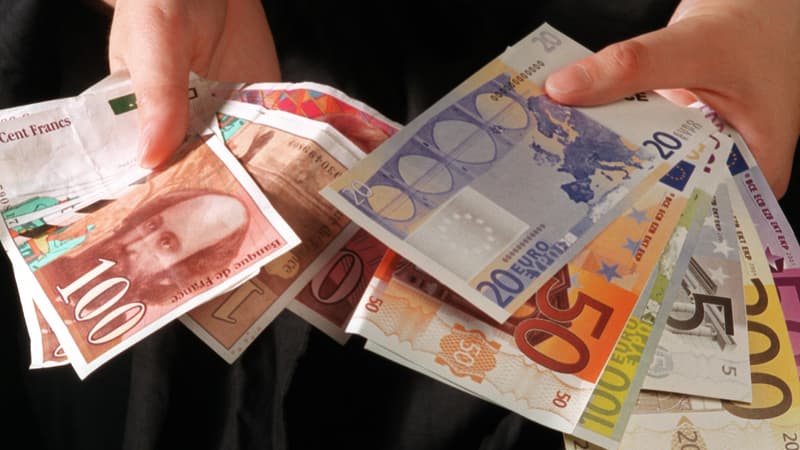 Une personne présente des billets de 100 et 200 francs français et des billets factices de 5, 20, 50, 100, 200 et 500 euros, en 2001, avant la mise en circulation des billets de la nouvelle monnaie unique