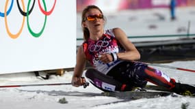 La sportive américaine Sophie Caldwell se repose sur la neige à la fin d'un cross-country de 10.000 mètres, le 13 février 2014.
