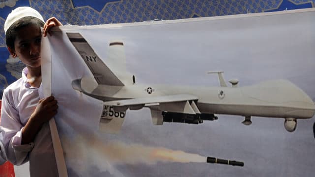 Un jeune pakistanais du groupe islamiste radical Jamaat-ud-Dawa tient une bannière pour dénoncer les attaques des drones américains, à Lahore le 5 juillet 2013.