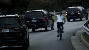 Une femme fait un doigt d'honneur au convoi de Donald Trump, le 28 octobre 2017 à Sterling, en Virginie. 