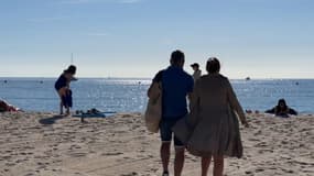 Des promeneurs sur une plage de la Côte d'Azur.