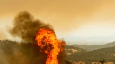 Un hélicoptère se prépare à arroser d'eau l'incendie Ranch Fire, partie du Mendocino Complex, qui enflamme la route de High Valley, près de Clearlake Oaks, en Californie. Un hélicoptère se prépare à arroser d'eau l'incendie Ranch Fire, partie du Mendocino Complex, qui enflamme la route de High Valley, près de Clearlake Oaks, en Californie.