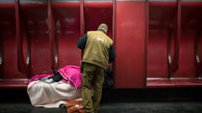 Un travailleur social de la RATP parle à un SDF dans une station de métro à Paris, le 27 mars 2013