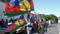 Des manifestants brandissent des drapeaux du Front de libération nationale kanak socialiste (FLNKS) alors qu'ils participent à un rassemblement organisé par la coalition indépendantiste de la Cellule de coordination de terrain (CCAT) devant le palais de justice de Nouméa en soutien aux 14 militants jugés pour entrave circulation et dégâts matériels, le 13 mai 2024.