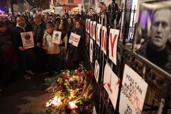 Des personnes portent des pancartes devant l'ambassade de Russie à Londres, le 16 février 2024, à la suite de l'annonce de la mort de l'opposant russe Alexei Navalny. 