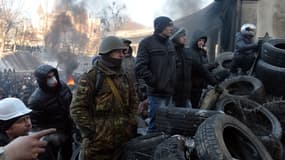 Des opposants surveillent une barricade pour prévenir une attaque de la police, vendredi 24 janvier, à Kiev.