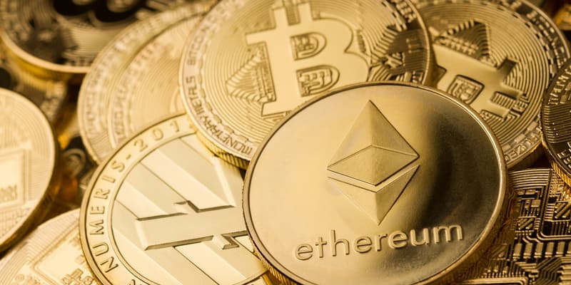 Des pièces à l'effigie de différentes cryptomonnaies comme le bitcoin ou l'ether.