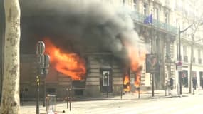 Sur les Champs-Elysée, des manifestants ont mis feu à une agence bancaire. 