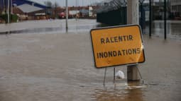 Un panneau portant l'inscription "ralentir inondations" est placé à l'entrée d'une zone inondée à Arques, dans le Pas-de-Calais, le 3 janvier 2024, à la suite de la crue de l'Aa