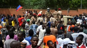 Des manifestants acclament des militaires devant l'ambassade de France après un rassemblement en soutien aux soldats putschistes au Niger, le 30 juillet 2023 à Niamey