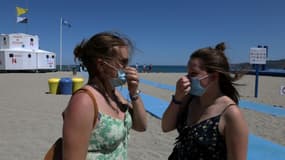 Deux femmes mettent leur masque à leur retour de la plage où il n'est pas obligaoire, le 17 juillet 2021 à Argelès-sur-Mer 