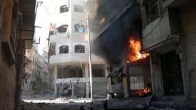 Incendie à Homs après un bombardement, dimanche. L'armée syrienne a poursuivi son offensive sur des localités de la banlieue de Damas et dans plusieurs villes du pays au lendemain de la conclusion d'un accord à Genève sur les principes d'une transition po