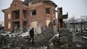 Un homme marche entre des maisons détruites dans la ville de Bila Tserkva, dans le centre de l'Ukraine, le 8 mars 2022
