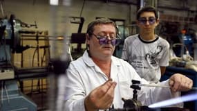 Un salarié expérimenté (G) explique le travail à un jeune dans une fabrique de verre à Joinville-le-Pont, le 29 juin 2012