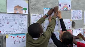 Les enfants collent des dessins sur le centre social du Pile à Roubaix après l'incendie du bâtiment.